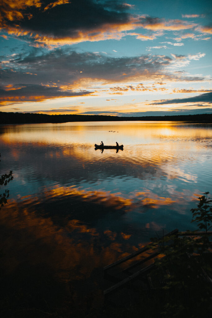sunset on lake with canoe
